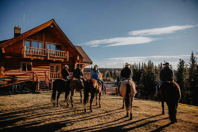 People riding horses at a ranch in Canada