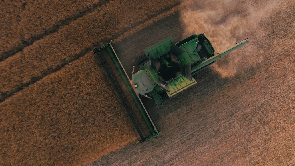 Image of a harvester on a brownfield on the top farm for sale in Canada